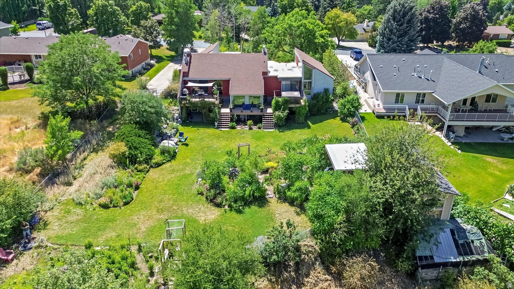 Multi-level residence featuring a red roof and exterior, multiple rear balconies, and an expansive lawn