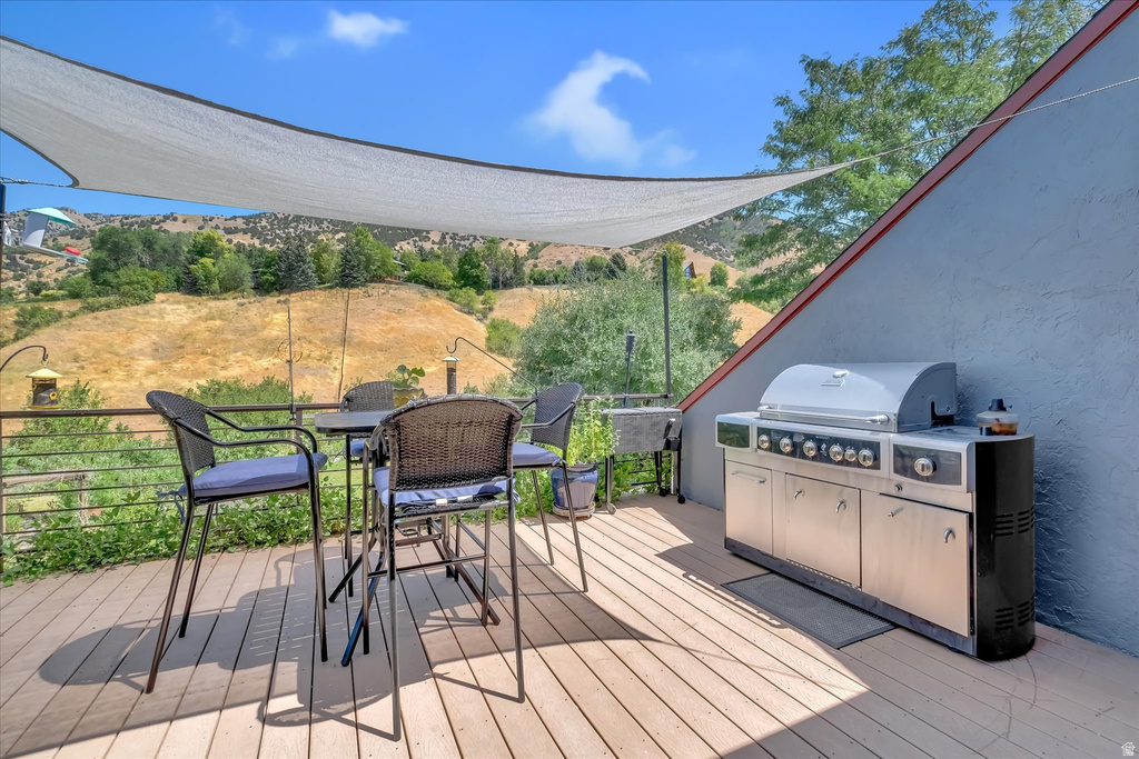 Spacious outdoor deck featuring wood-finish flooring and a partial shade canopy