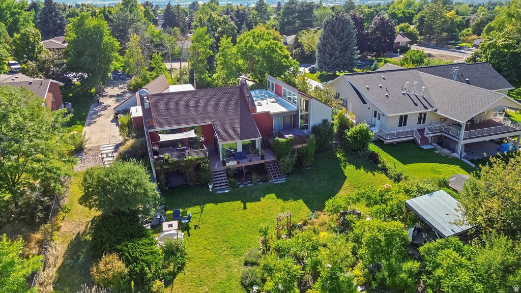 Expansive property featuring a multi-level structure with a tiered deck, a covered patio, and a sloped lawn