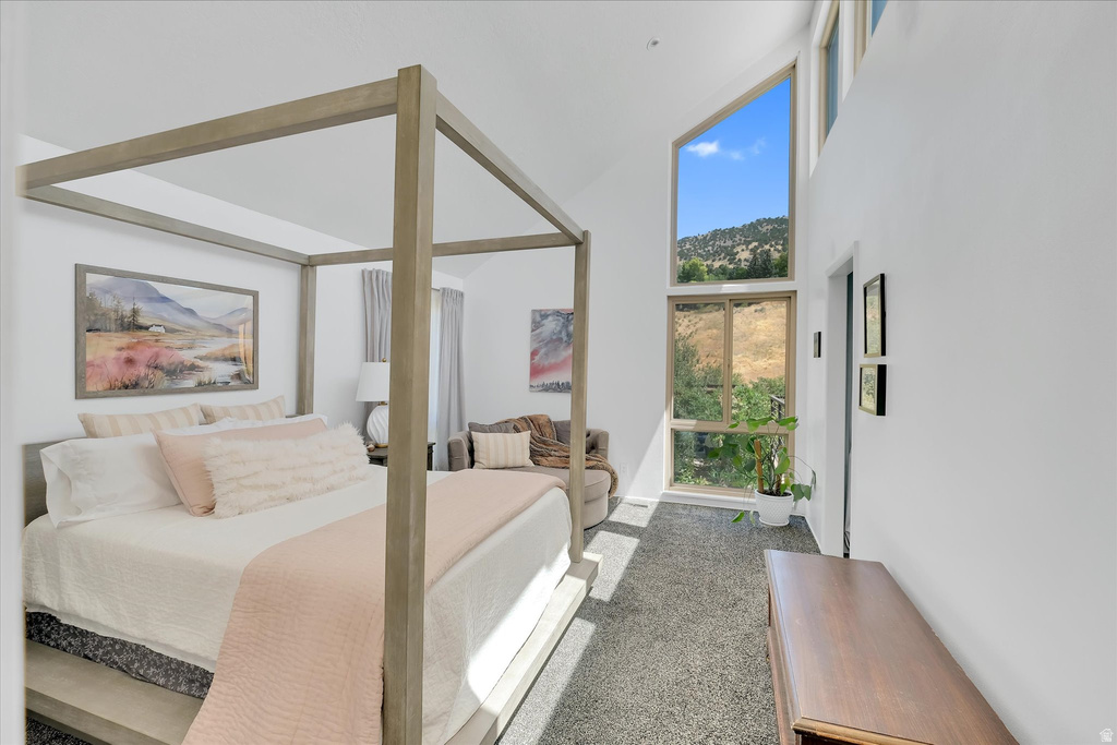 Room featuring a vaulted ceiling and a large, multi-paned window providing expansive outdoor views
