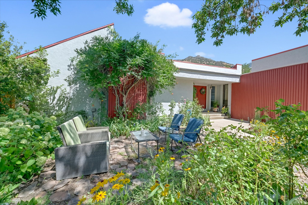 Stucco exterior featuring red accent siding and a contrasting orange entry door