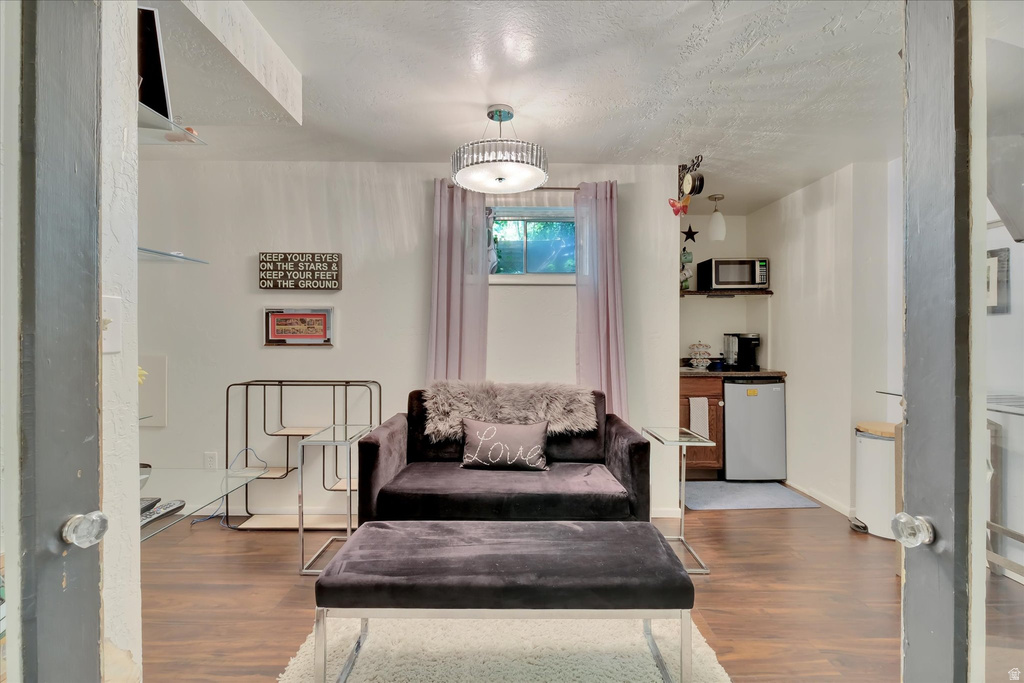 Recreational room featuring wood-finish flooring, a built-in wet bar with cabinetry, and a ceiling-mounted light fixture