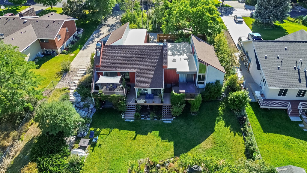 Multi-level residential structure featuring a dark shingle roof and a vibrant red facade