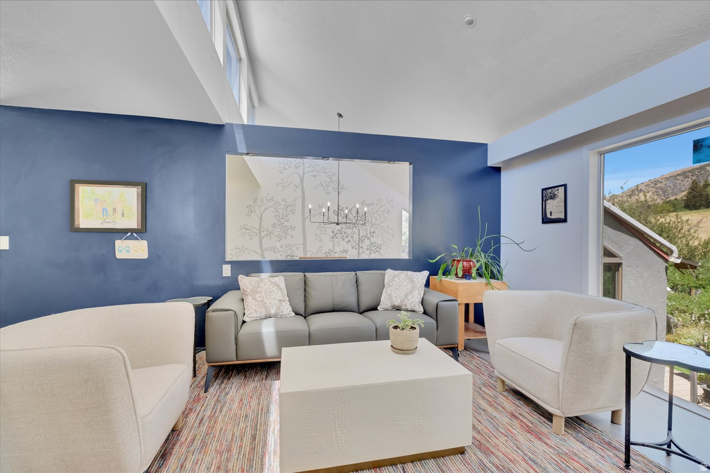 Living area featuring a vaulted ceiling with clerestory windows, a large picture window, and a decorative wall mirror