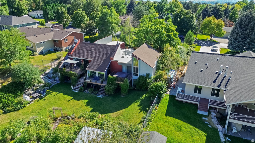 Multi-level property featuring a large backyard, extensive decking, and mature landscaping