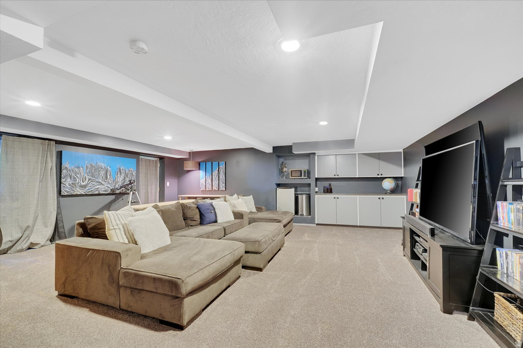 Carpeted recreation room featuring recessed lighting, a built-in entertainment center, and integrated cabinetry with shelving