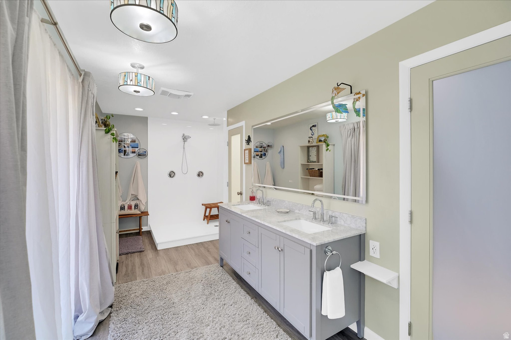 Bathroom featuring a dual vanity with light gray cabinetry, white rectangular sinks, and a light-colored speckled countertop