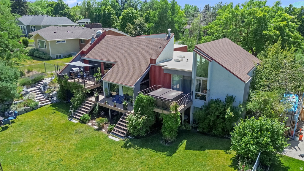 Multi-level residence featuring extensive decking, a hot tub, and exterior staircases