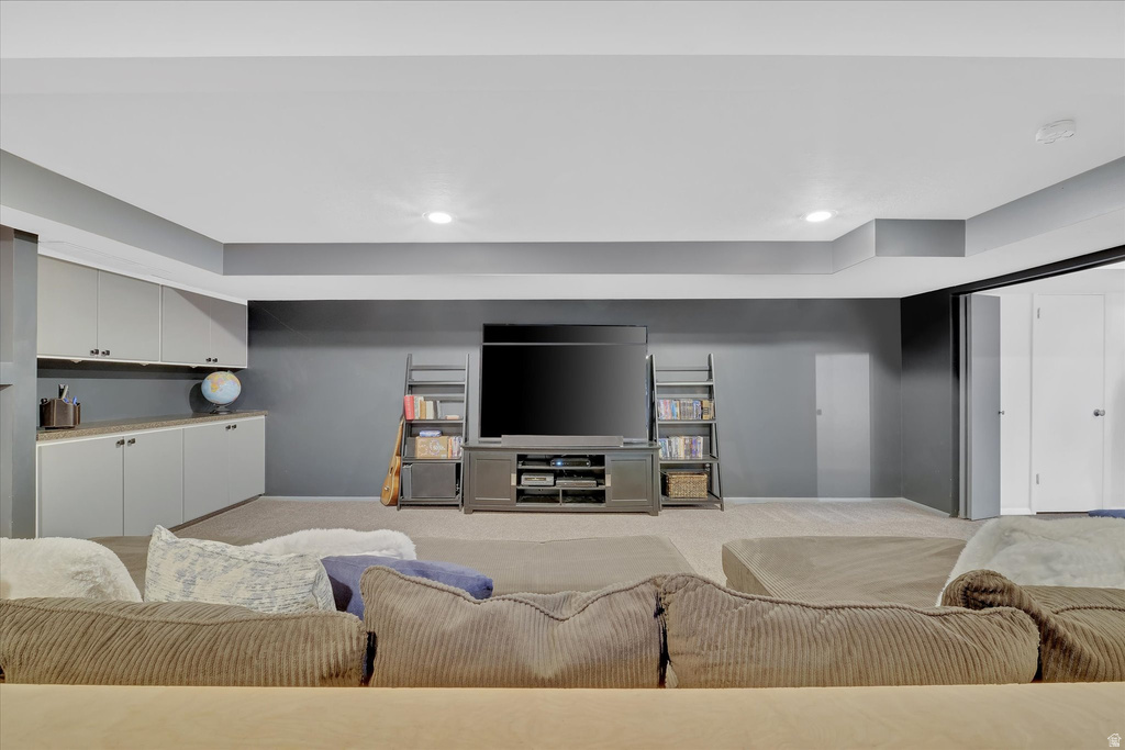 Spacious room featuring recessed lighting, a built-in media center, floor-to-ceiling shelving, and integrated cabinetry with a countertop