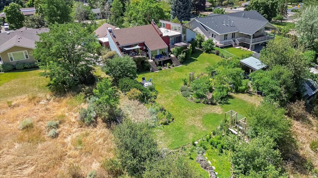 Tiered landscaping with expansive green lawn, mature trees, and established garden beds