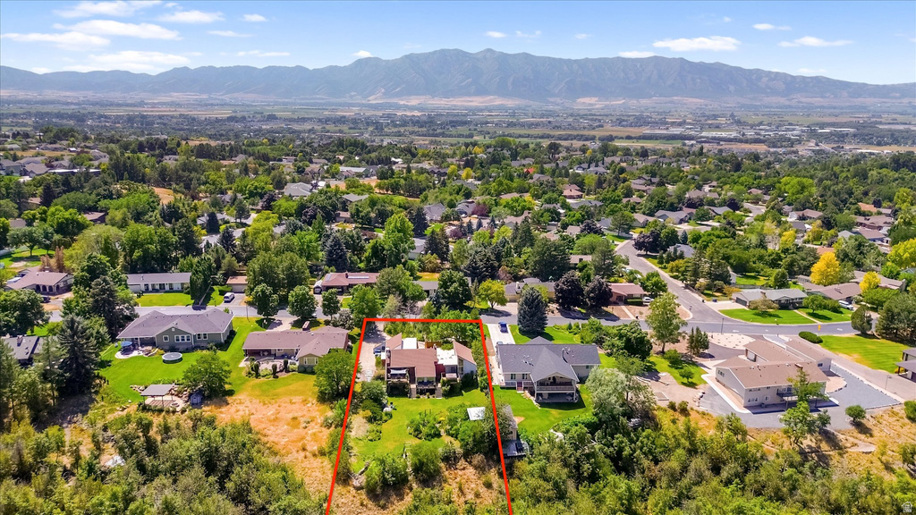Expansive residential property with a multi-level home featuring a brown roof and light-toned siding, set on a verdant lot