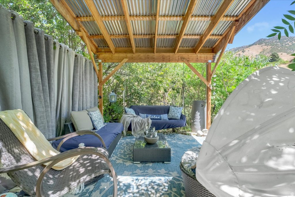 Outdoor patio featuring a corrugated metal roof, exposed wood beams, and a patterned area rug