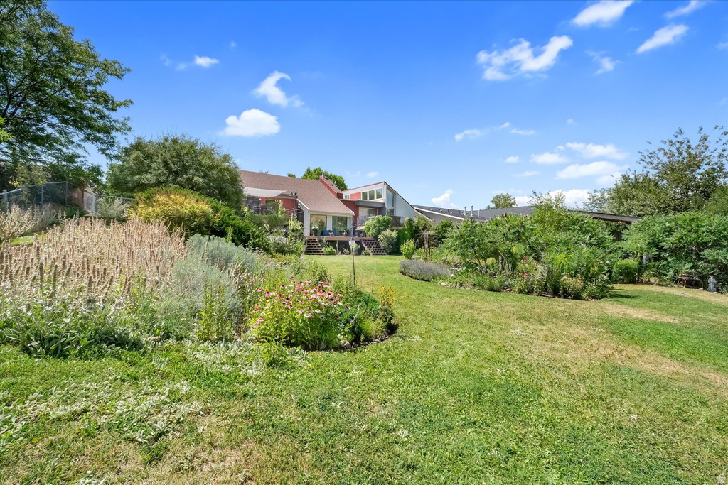 Expansive green lawn surrounded by mature landscaping and diverse plant beds