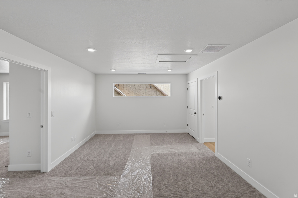 Spacious room with gray carpeting and white baseboards