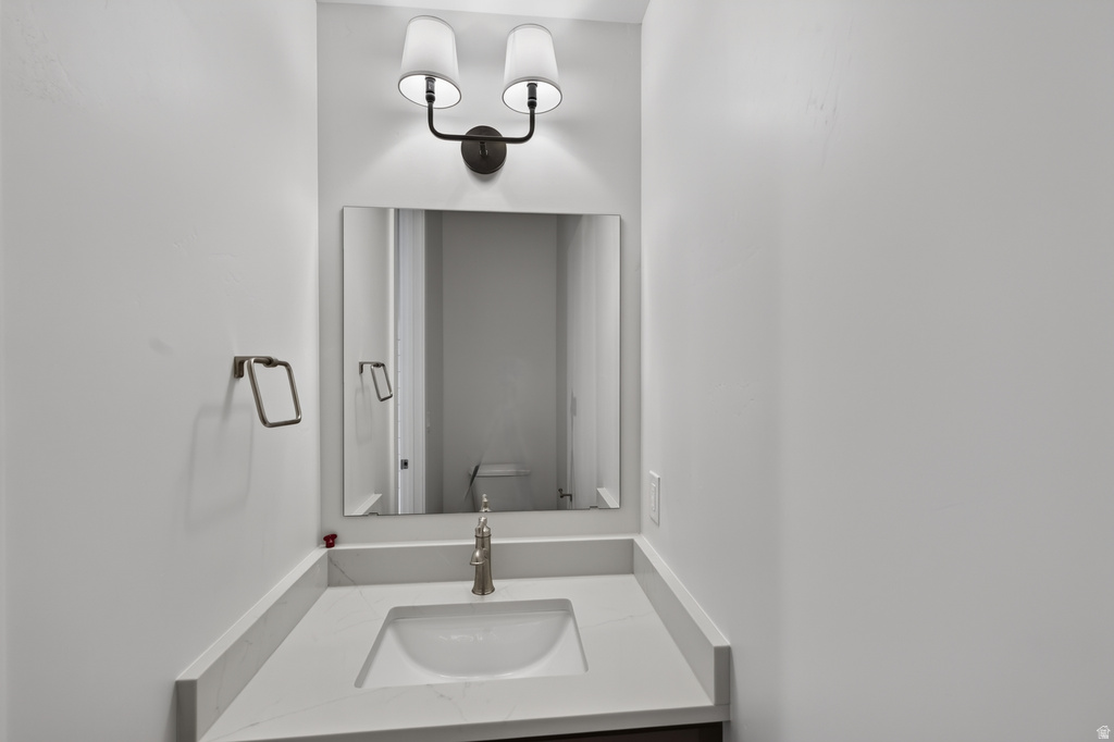 Vanity with an integrated sink, light-toned countertop, and brushed nickel faucet