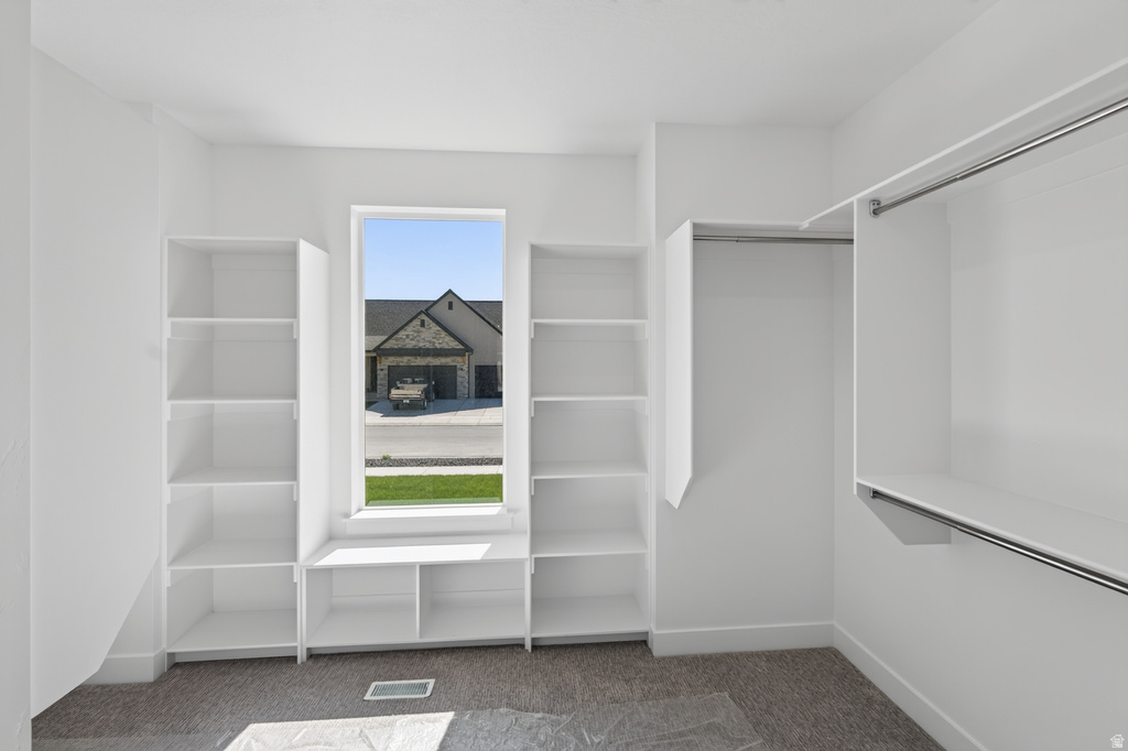 Built-in shelving units with an integrated window seat, complemented by a dedicated hanging rod and additional shelving