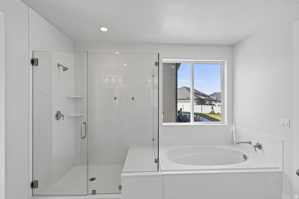 Contemporary bathroom featuring a glass-enclosed shower with built-in shelving, a built-in tub, polished chrome fixtures, and a recessed ceiling light