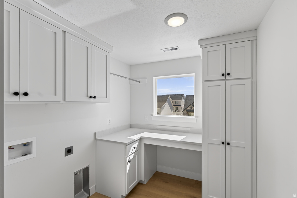 White shaker cabinetry with black hardware, integrated countertop, and built-in workstation