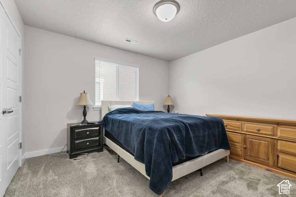 Carpeted room featuring a window with blinds, white paneled door, and a flush mount ceiling light fixture