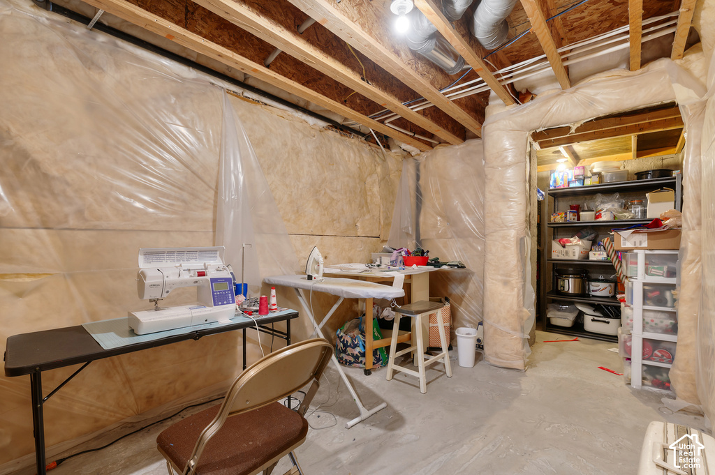 Unfinished basement space featuring exposed wood joists and concrete flooring