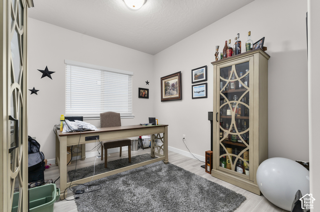 Light-filled room featuring wood-finish flooring, a contemporary ceiling light fixture, and a window with blinds