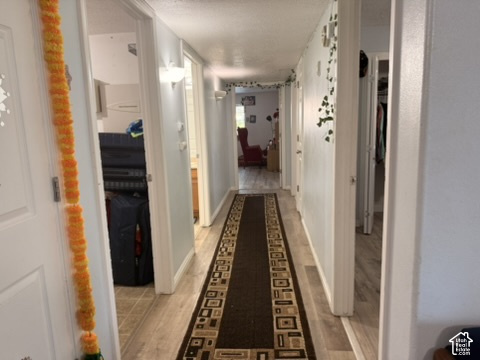 Hallway featuring wood-finish flooring and light-colored walls
