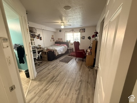 Spacious room featuring wood-finish flooring, a window offering natural light, and a ceiling fan