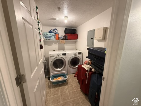 Dedicated laundry area featuring dual front-loading machines, overhead shelving, and neutral-toned tile flooring