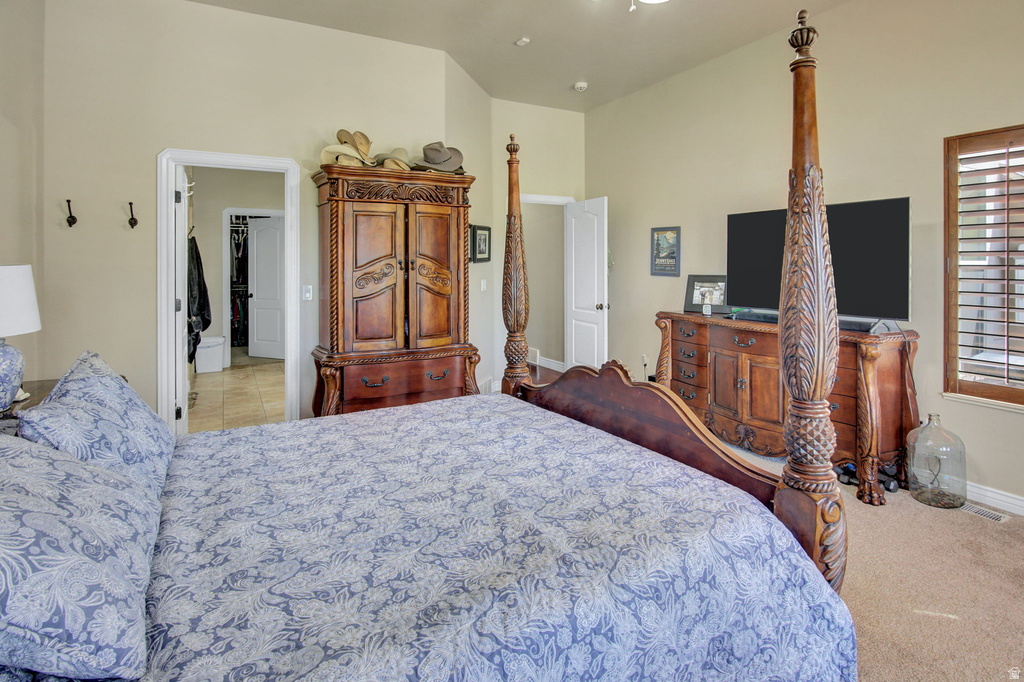 Spacious room featuring vaulted ceilings, a large window with wood plantation shutters, and light-colored walls