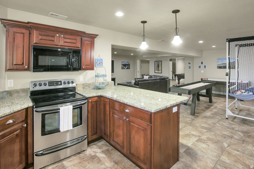 Kitchenette with wood-finish cabinetry, light-toned countertops, and stainless steel appliances