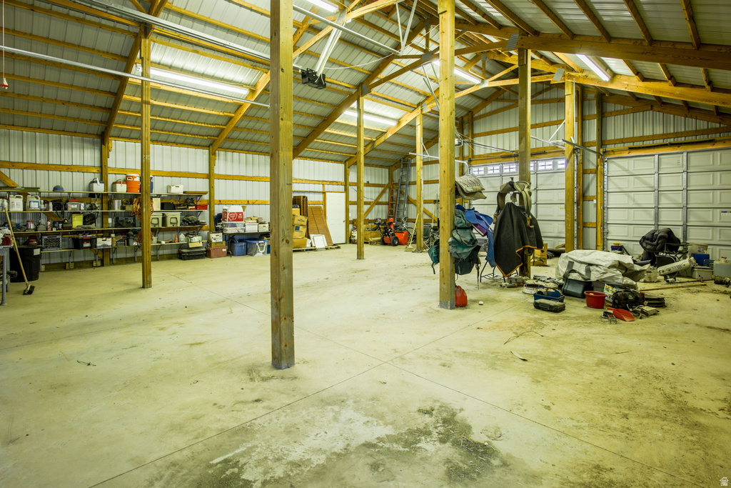 Spacious interior featuring a concrete floor, exposed wood beam construction, and a corrugated metal roof
