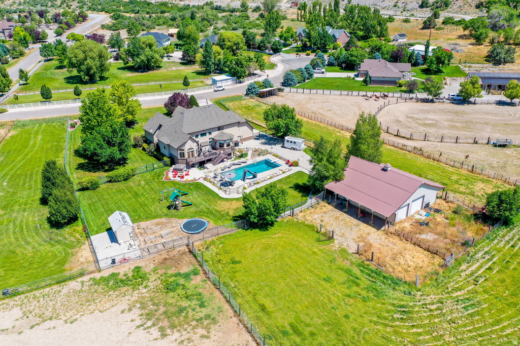 Expansive property featuring a multi-story residence with a wraparound deck, a large swimming pool with rock detailing, and a separate barn building