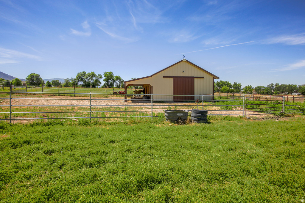Cream-colored barn featuring a brown roof and sliding doors