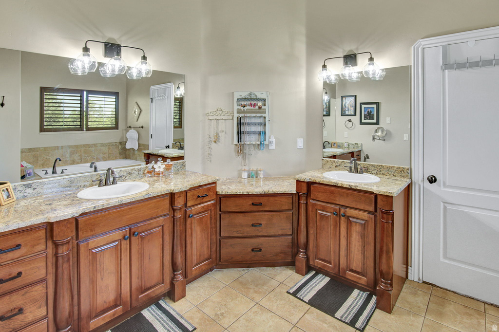 Bathroom featuring dual wood-finish vanities with granite countertops and undermount sinks