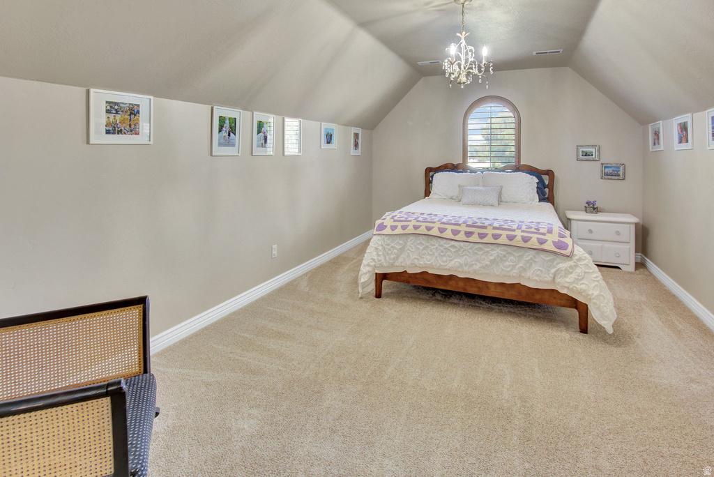 Carpeted room featuring an arched window with plantation shutters, a chandelier, and sloped ceilings