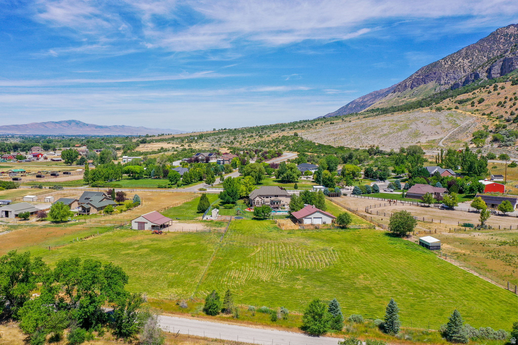 Expansive property featuring verdant fields, a mountainous backdrop, and mature trees