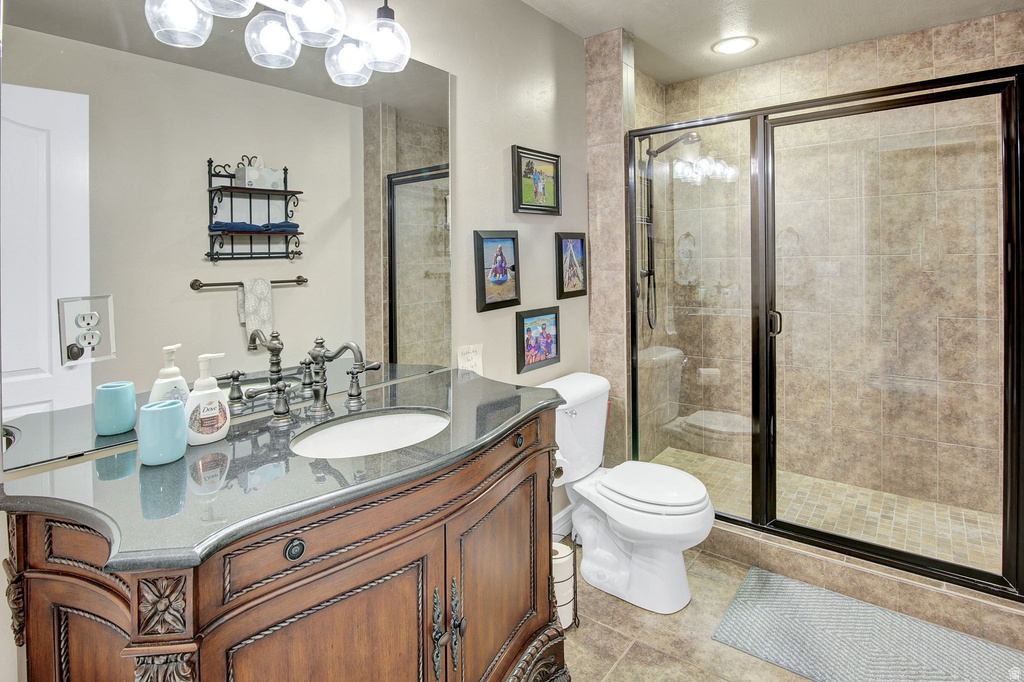 Bathroom featuring a rich wood-tone vanity with carved details, a dark countertop, an undermount sink, and an ornate faucet