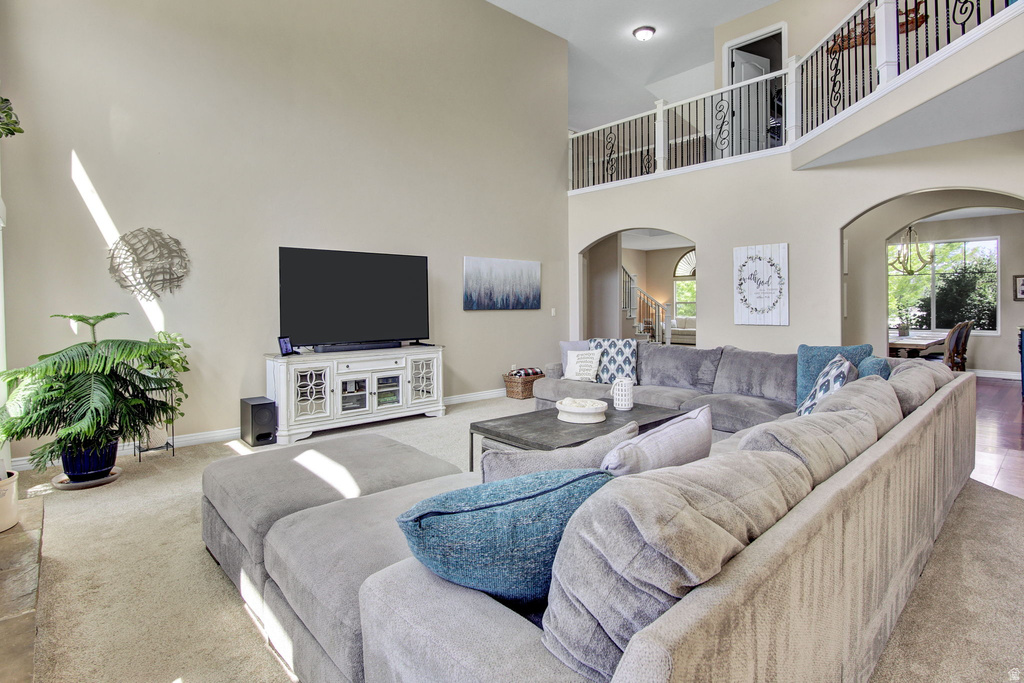 Two-story living area featuring vaulted ceilings, neutral wall tones, and arched doorways