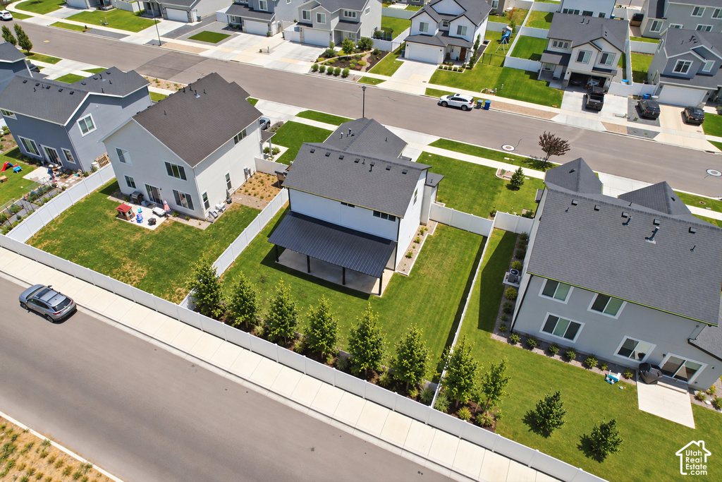 Expansive landscaped yard with a privacy fence, mature evergreen trees, and a paved patio area