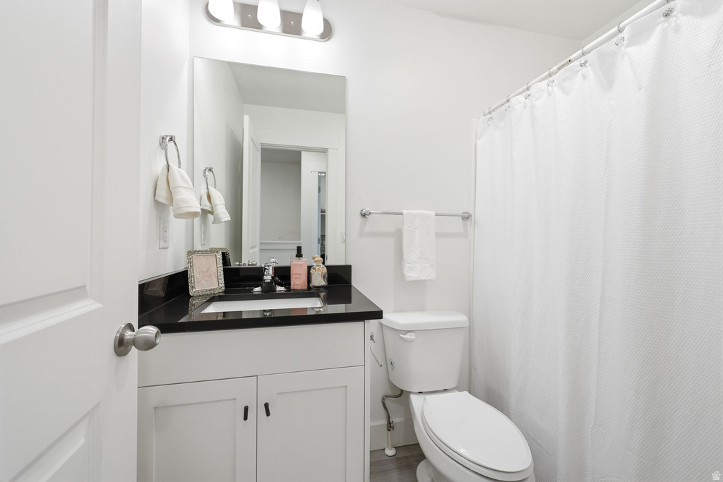 Bathroom featuring a white vanity with black countertop, undermount sink, and chrome fixtures