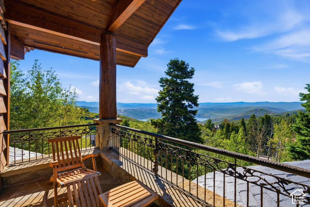 Covered balcony featuring wood-beam construction and a stone pillar