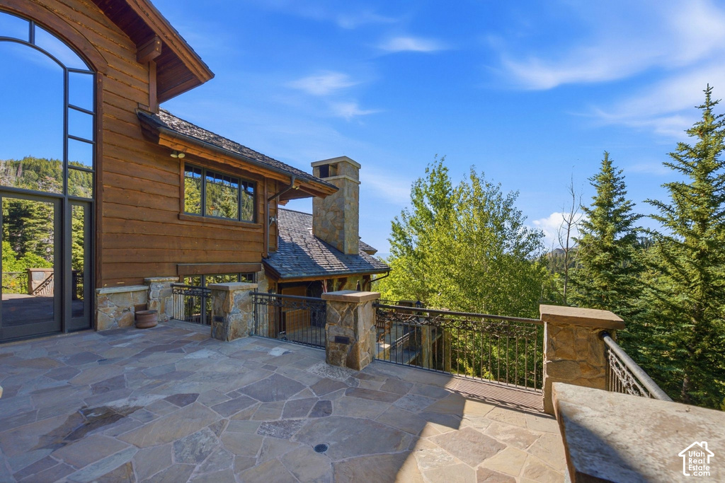 Stone patio featuring irregular flagstone paving and stone pillars with ornate metal railing