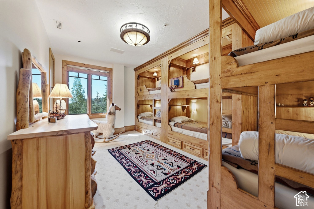 Room featuring built-in wooden bunk beds with individual lighting and storage drawers