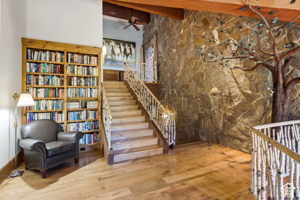 Hardwood flooring extends throughout this expansive space, featuring a stone accent wall with an integrated tree sculpture