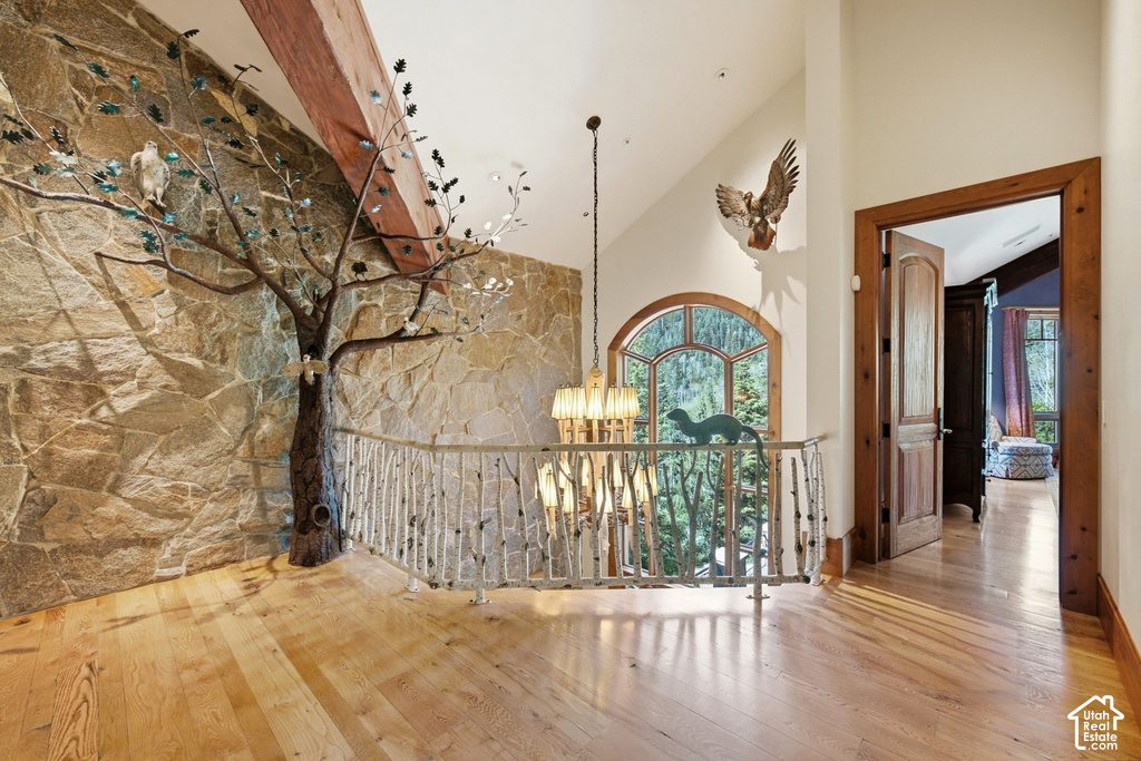 Stone accent wall featuring a decorative tree sculpture and exposed wood beam