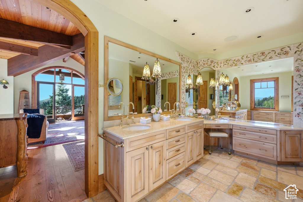Dual vanity with integrated sinks and brass fixtures, set into a light-toned wood-finish cabinetry