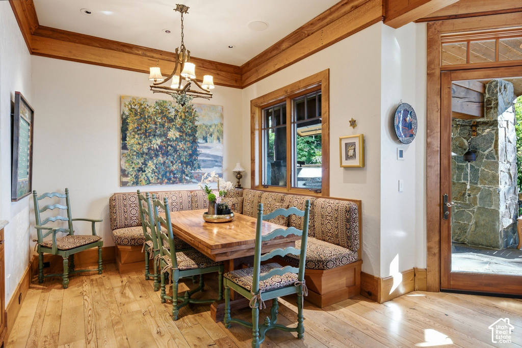 Dining space featuring wood-finish flooring, a built-in banquette, and a wood-framed window with exterior views