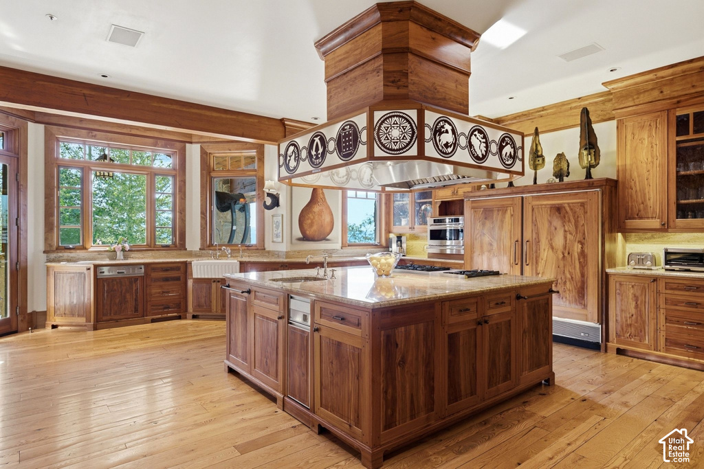Spacious kitchen featuring an expansive central island with a built-in cooktop, integrated dishwasher, and granite countertops