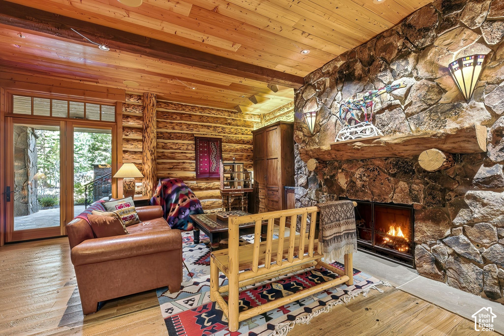 Stone fireplace featuring a rustic wood mantel and sconce lighting