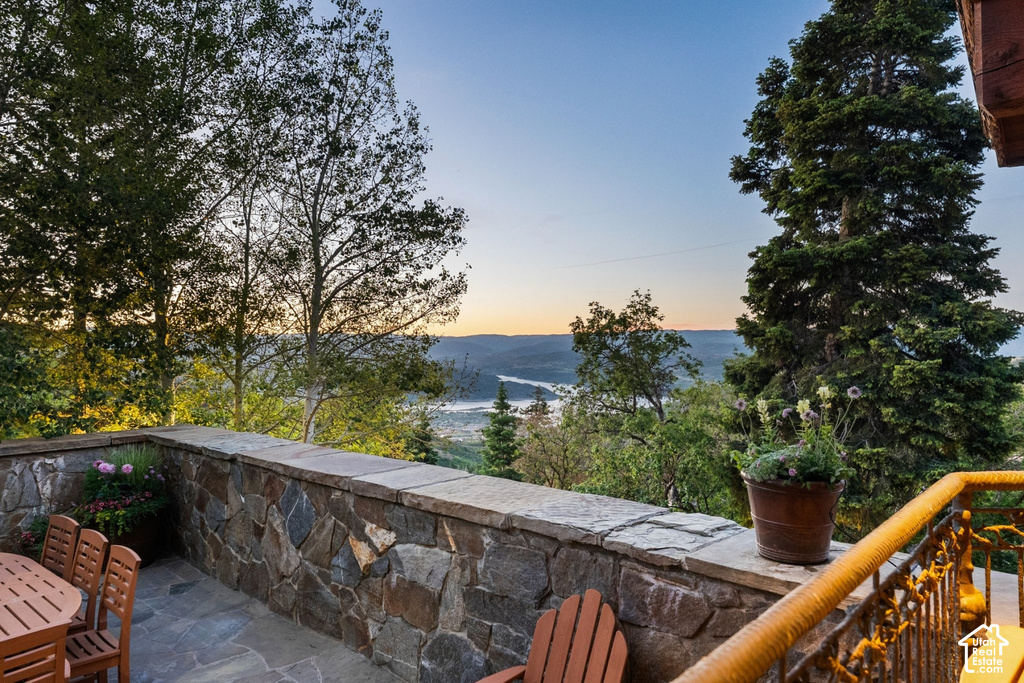 Stone-clad patio with flagstone flooring, solid stone wall, and metal railing